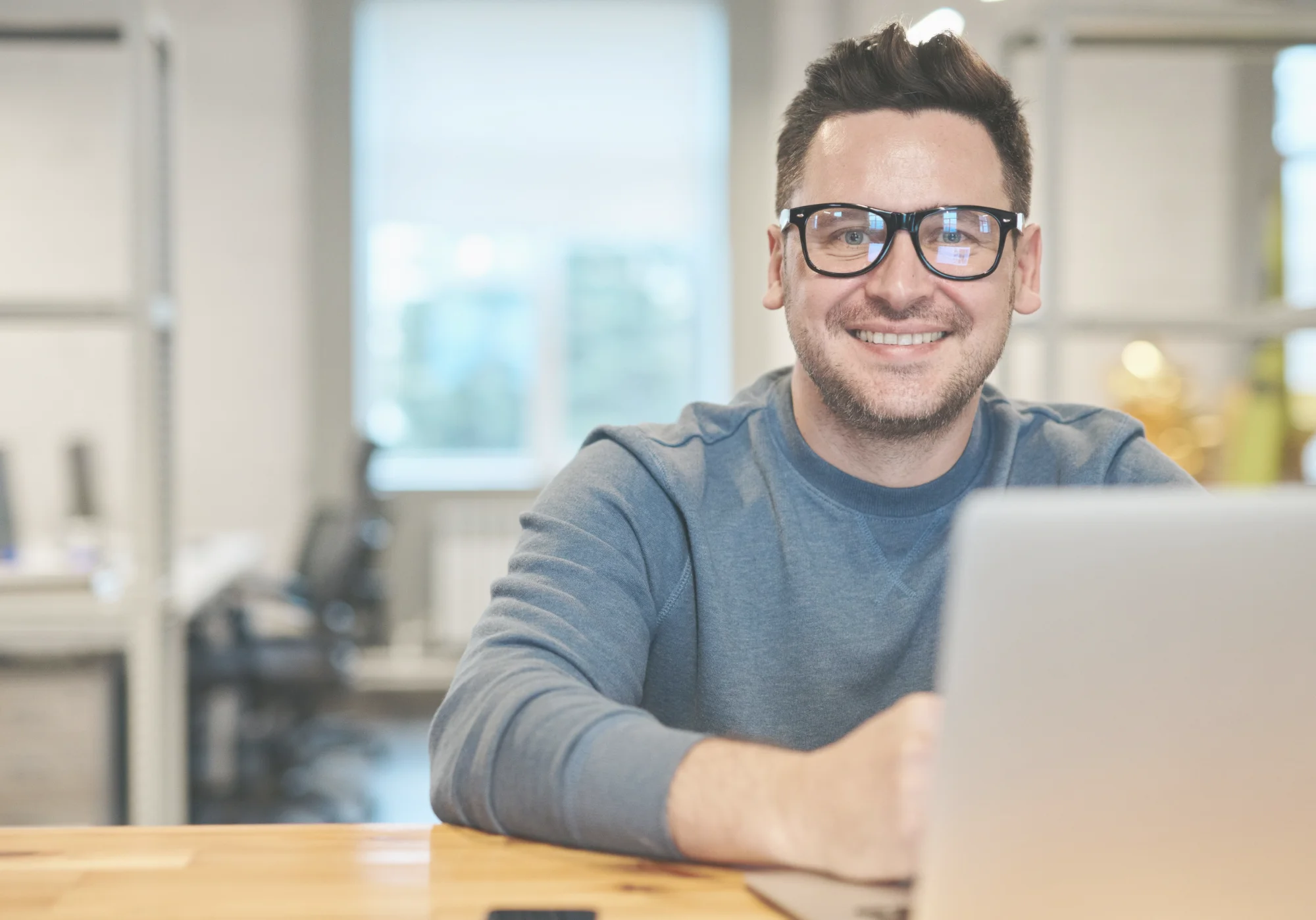 Estudiante sonriendo frente a su laptop