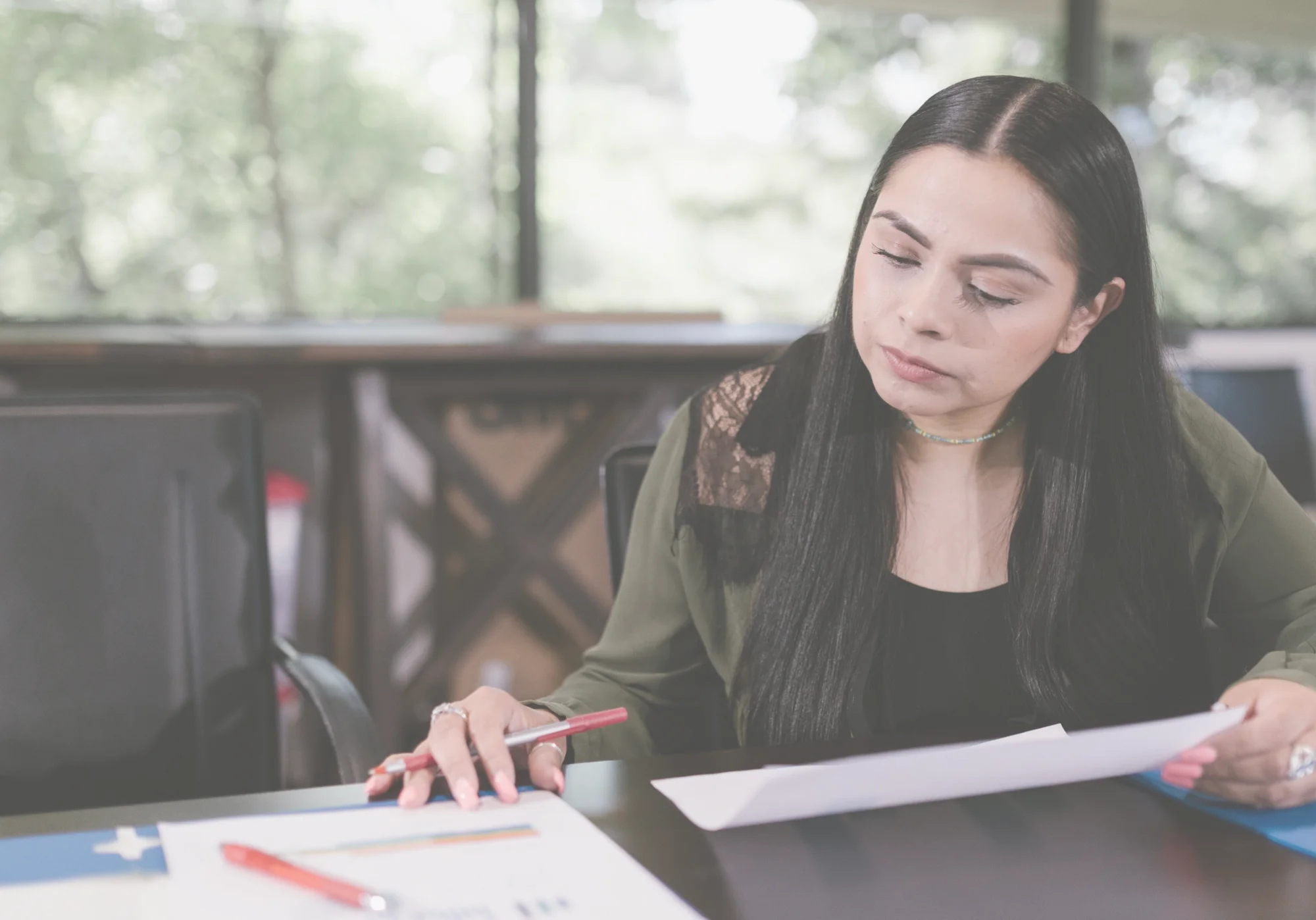 Profesional revisando documentos en una mesa de trabajo